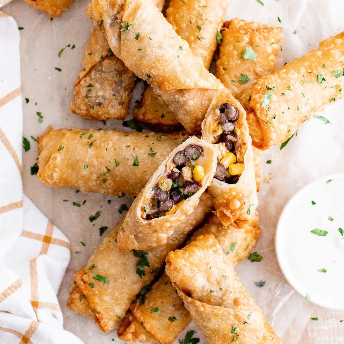 Top down view of several egg rolls and dipping sauce.