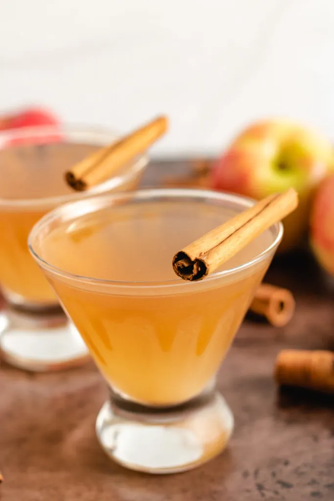 Cinnamon sticks sitting on top of martini glasses.