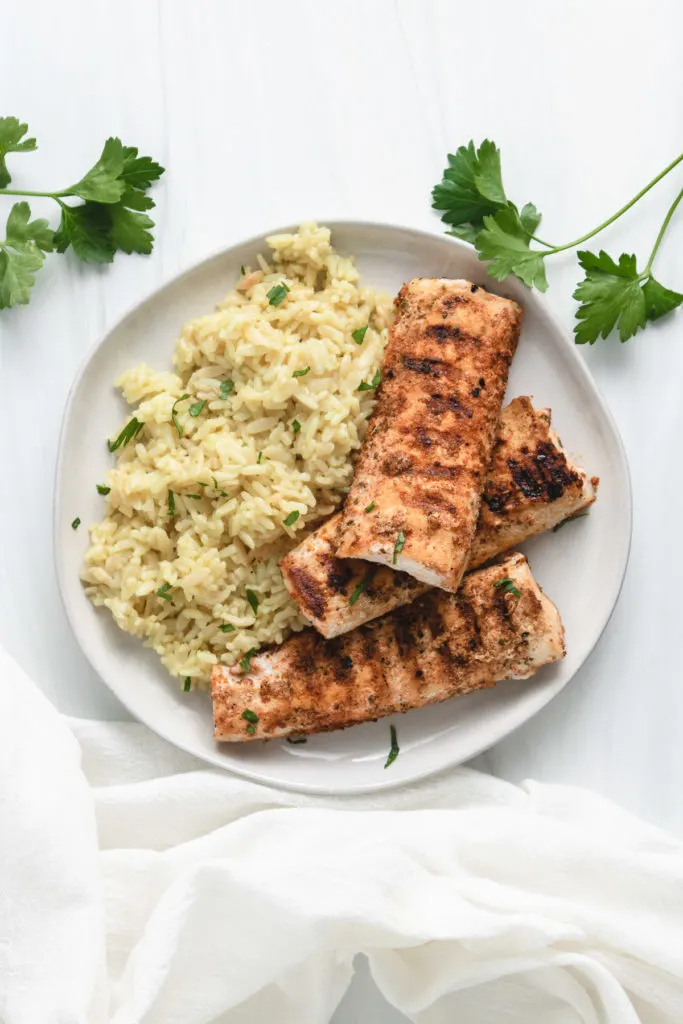 Top down view of grilled mahi mahi on a gray plate.