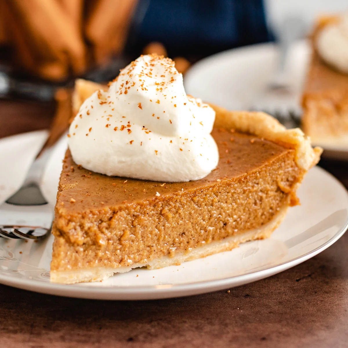 Pie with whipped cream and sprinkled cinnamon.