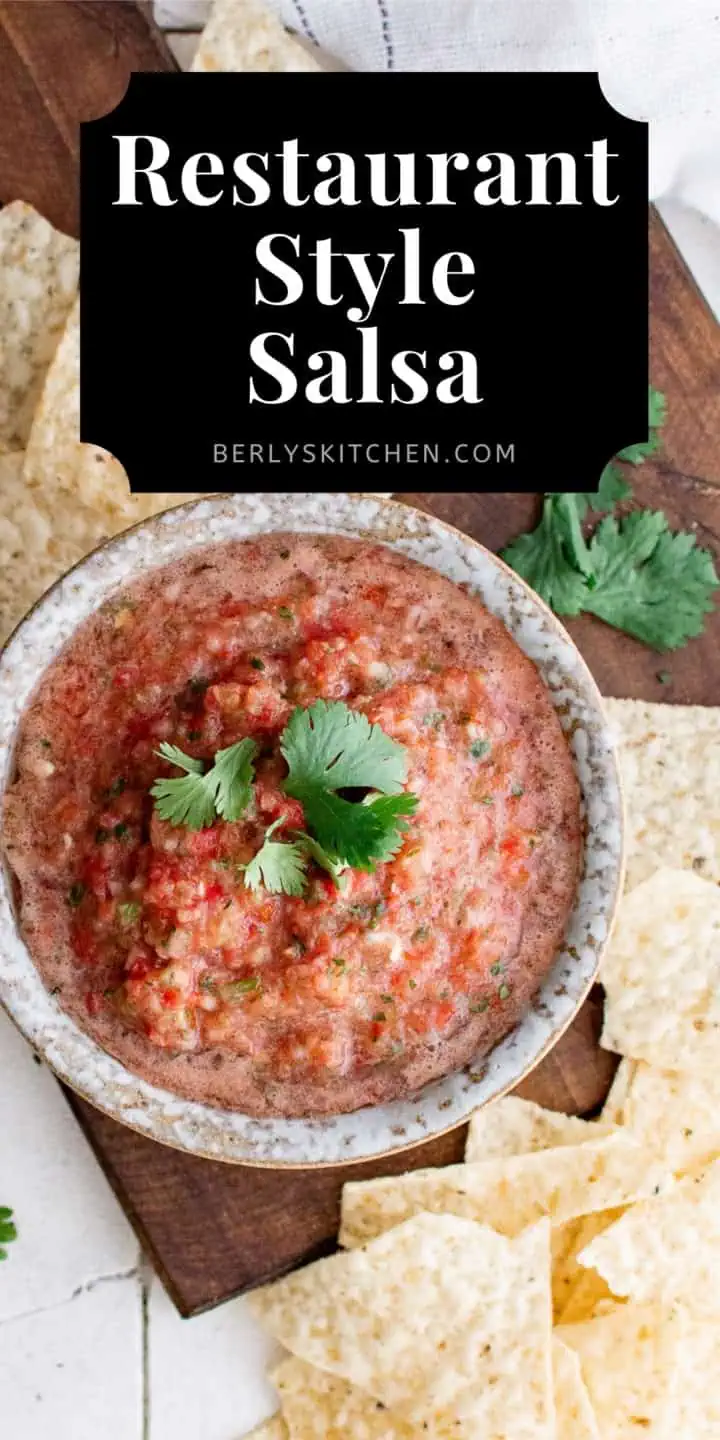 Top down view of salsa and chips on a cutting board.