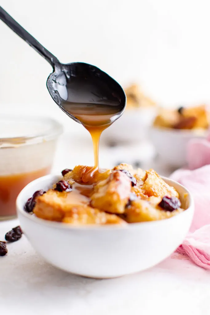 Salted caramel bourbon salt being poured on bread pudding.