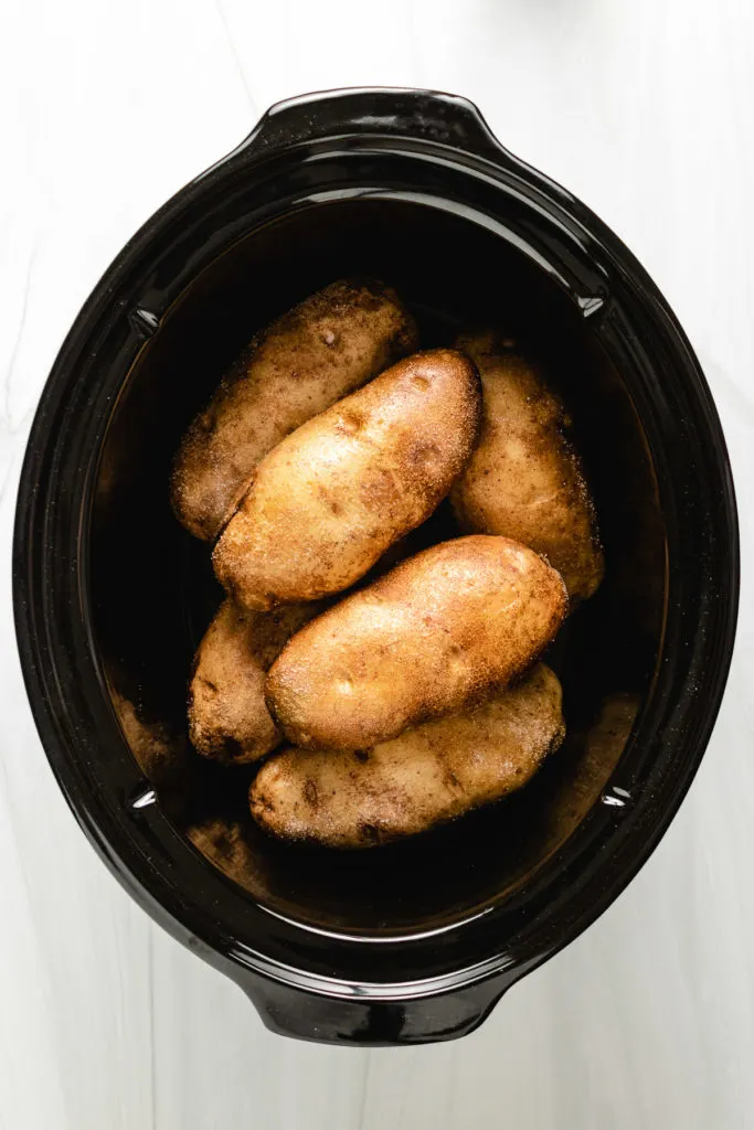 Top down view of russet potatoes in a slow cooker.