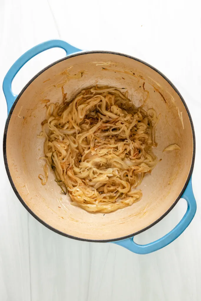 Top down view of onions being cooked in a pan.