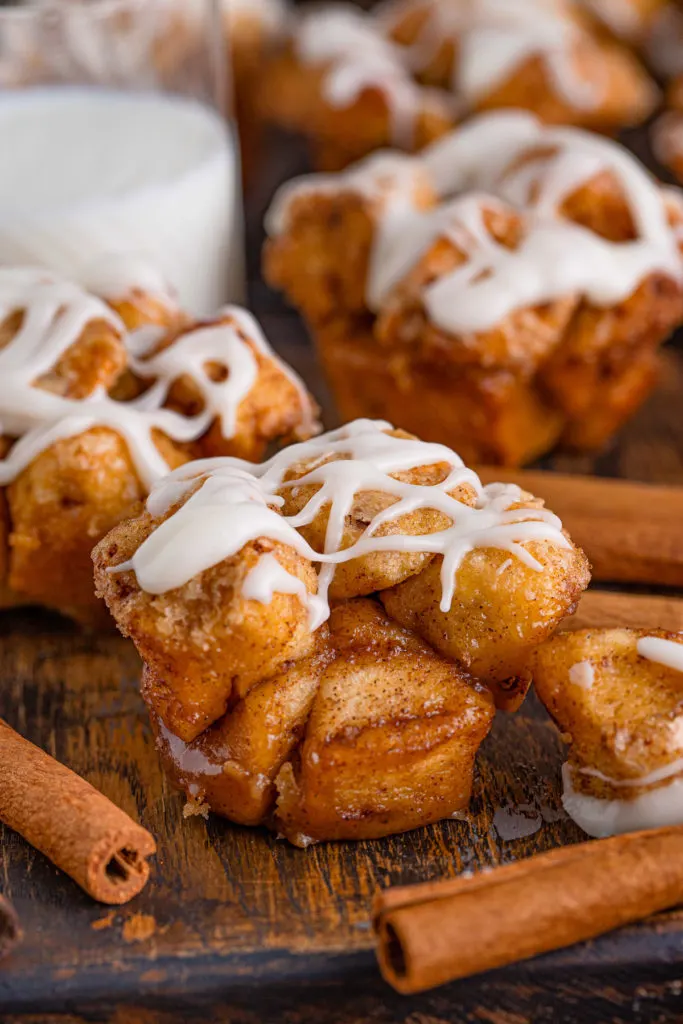 Monkey bread muffin next to a cinnamon stick.