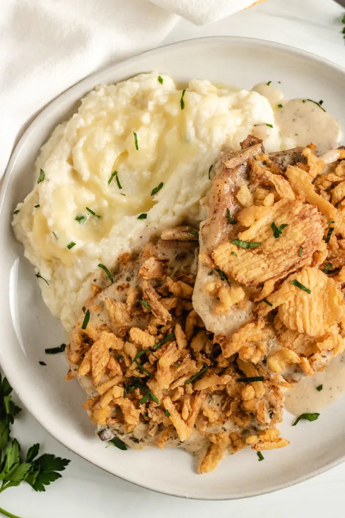 Top down view of pork chops and cauliflower on a plate.