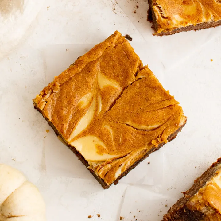 Top down view of cream cheese swirled in a pumpkin brownie.