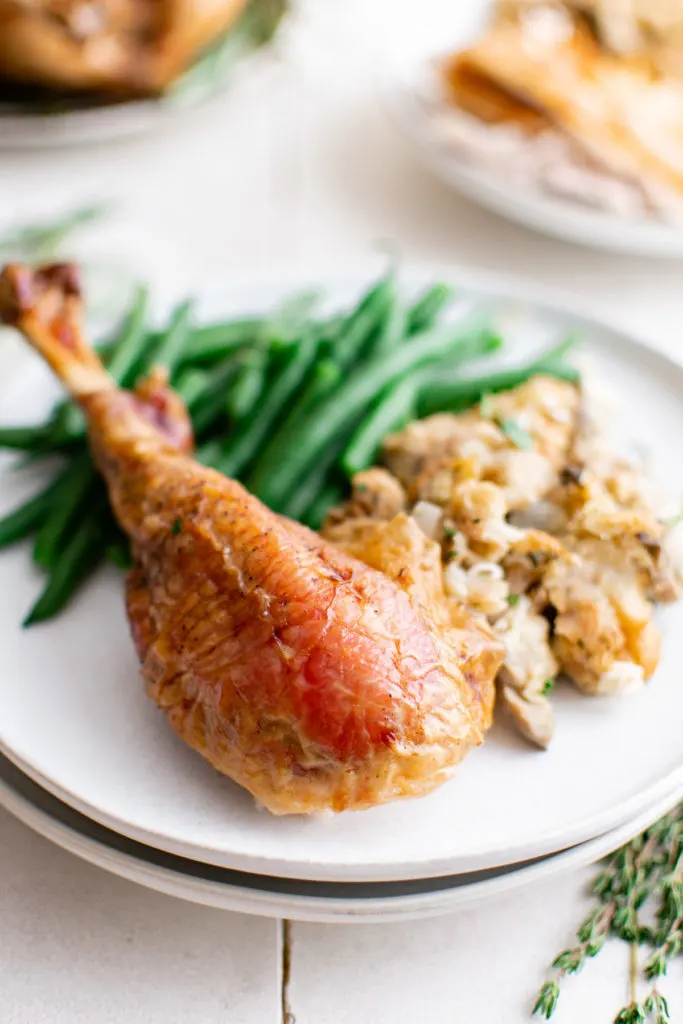 Green beans and a turkey leg on a plate.