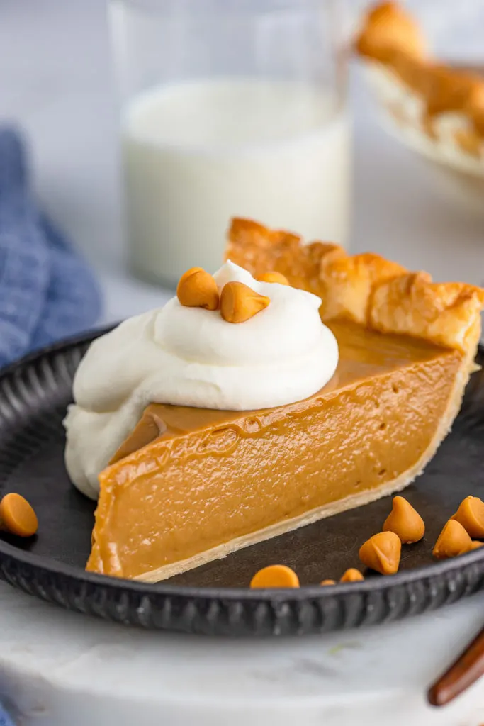 Close up of butterscotch pie topped with whipped cream.