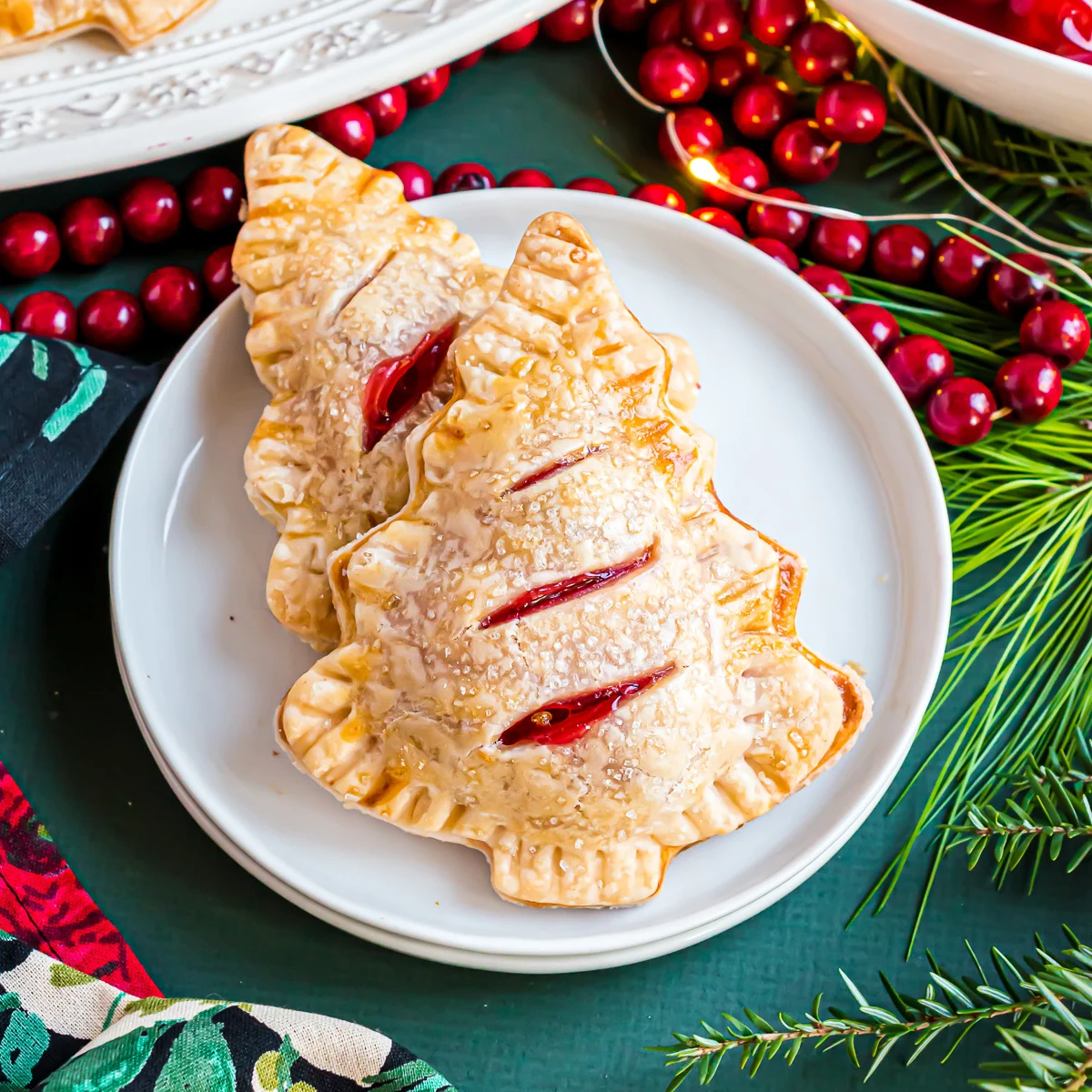 Two cherry hand pies on a white plate.