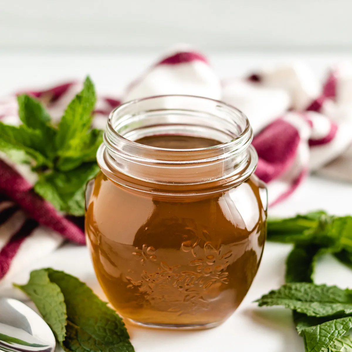 Mint simple syrup in a glass jar.