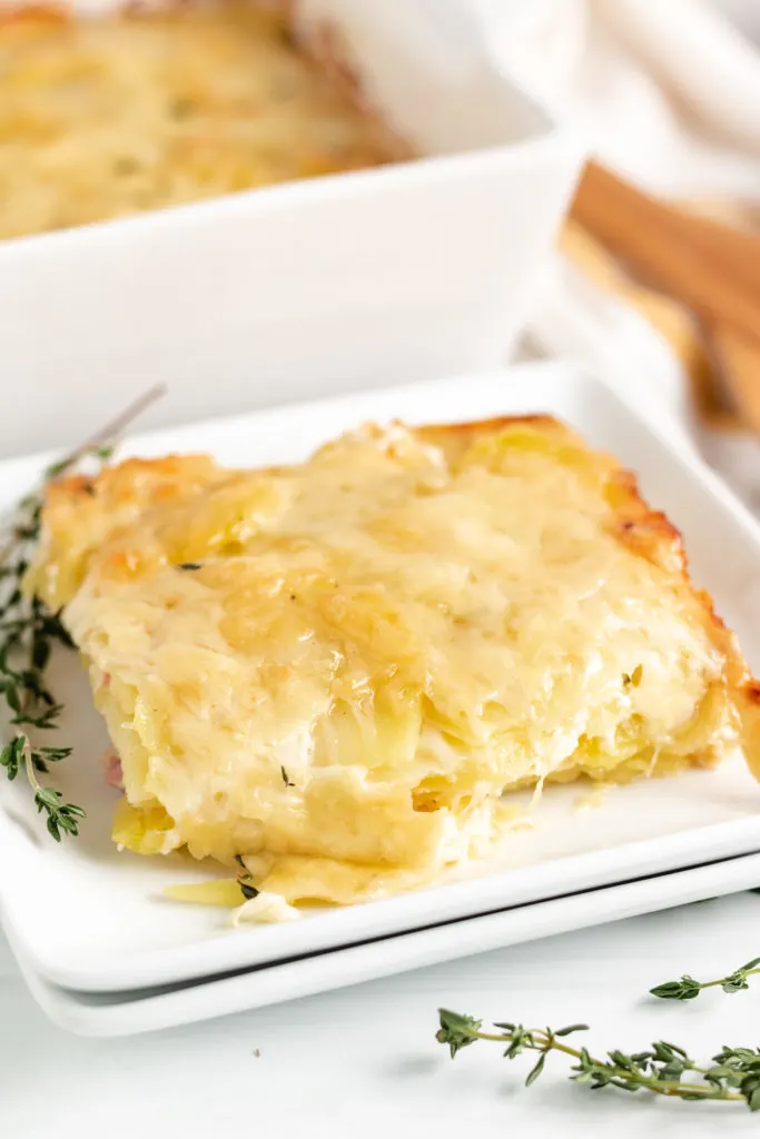 Scoop of potatoes au gratin on a serving plate.