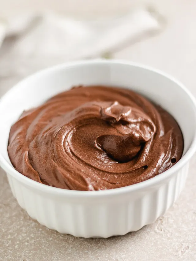 Large white dish filled with chocolate frosting.