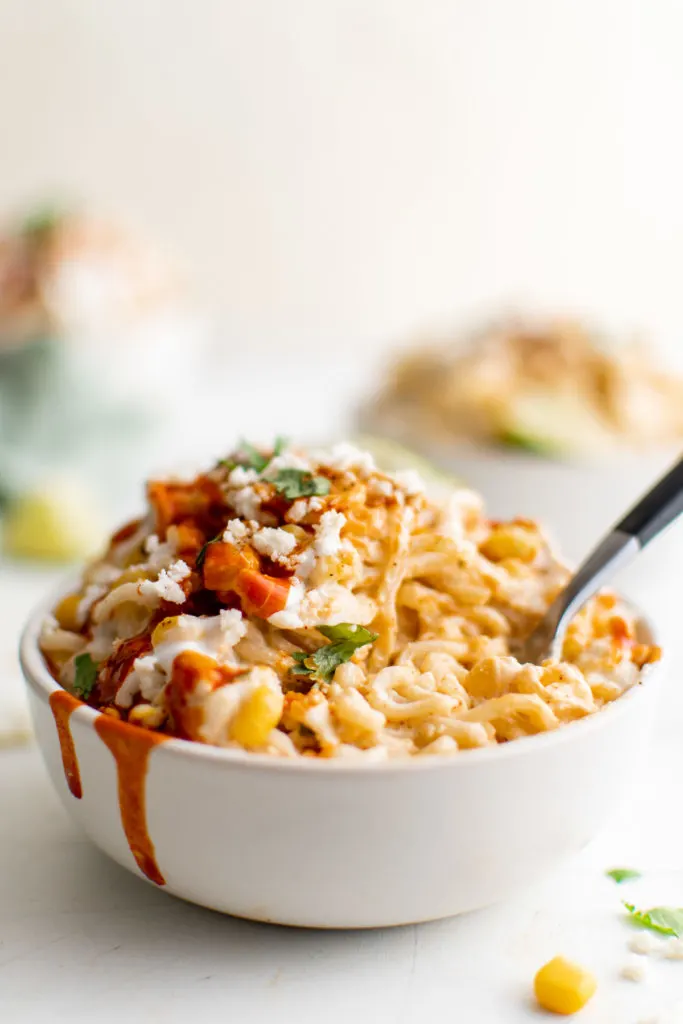 Bowl of elote ramen with hot sauce.