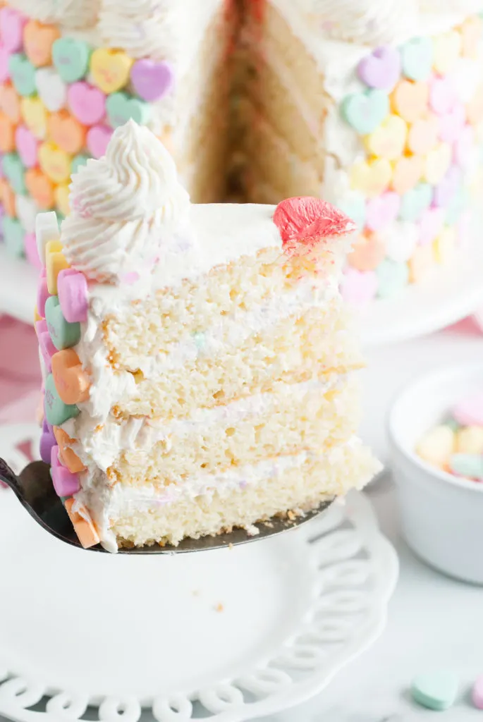 Slice of conversation heart cake on a spatula.