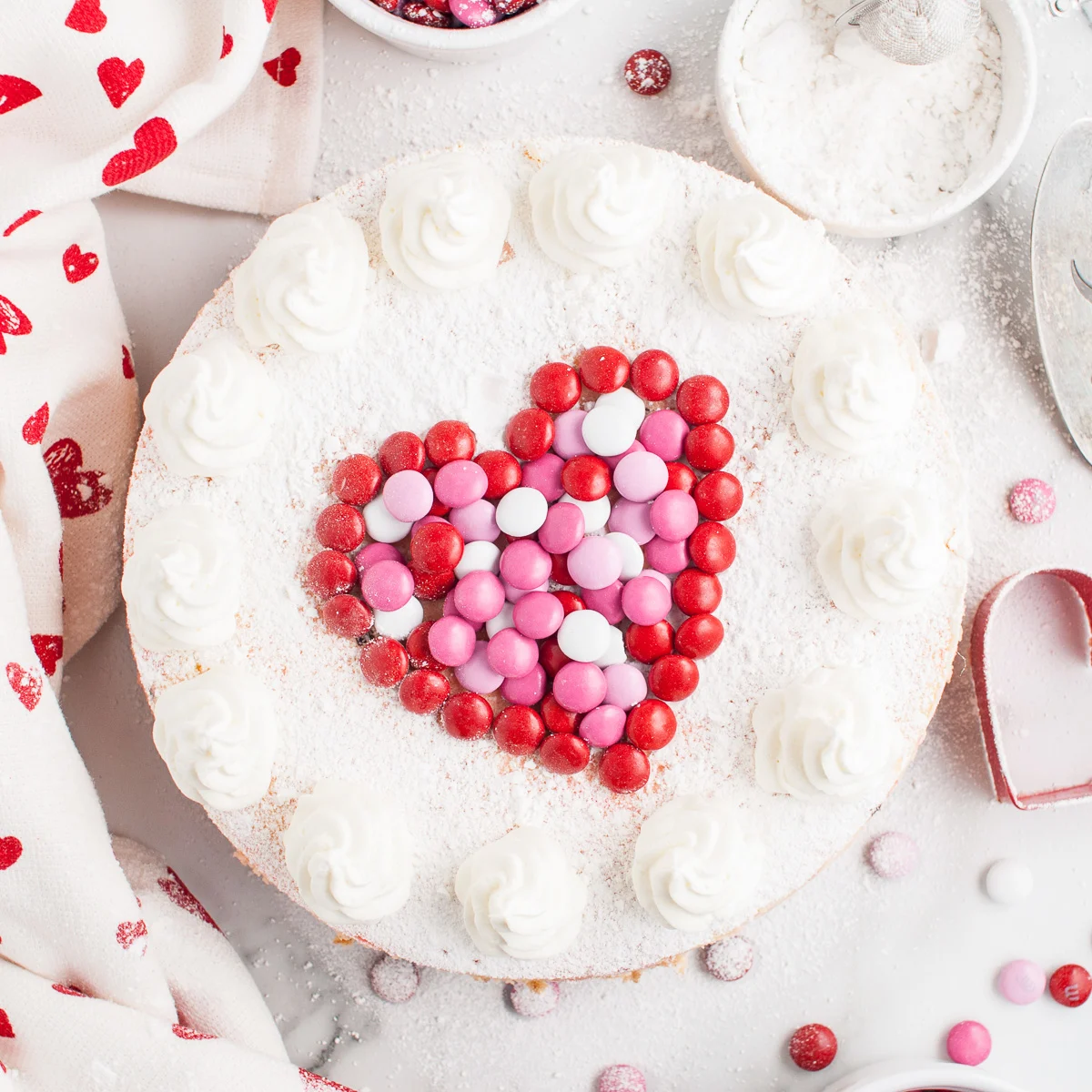 Top down view of a heart on top of an m&m cheesecake.