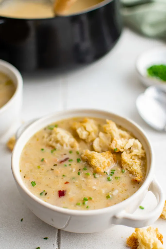 Potato leek soup topped with croutons in a bowl.