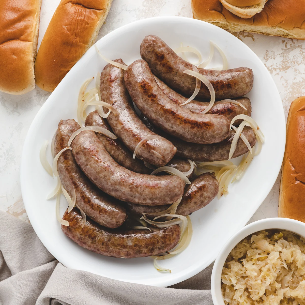 Bratwursts on a white dish.