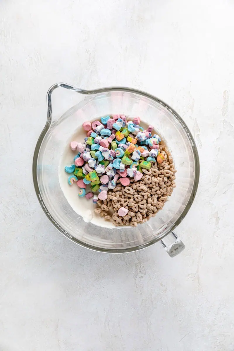 Cereal and marshmallows on top of whipped cream in a bowl.