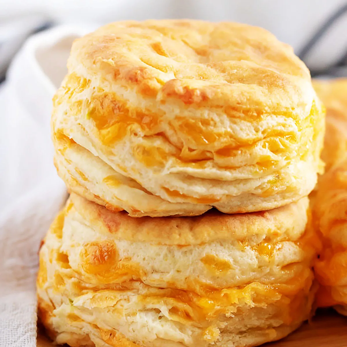 Stack of jalapeno cheddar biscuits on a wooden plate.