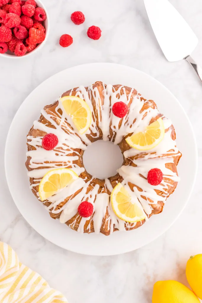 Top down view of a lemon raspberry cake on a stand.