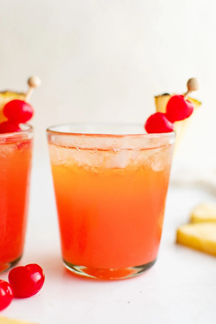 Side view of an orange cocktail in a glass.