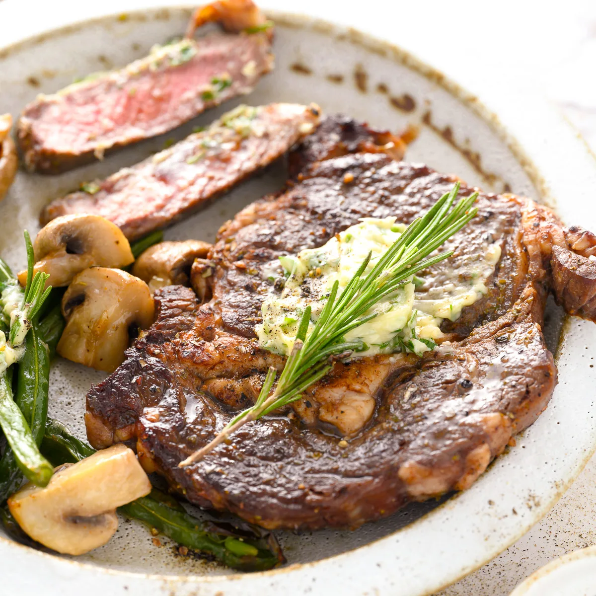 Side view of a pan seared steak on a plate.