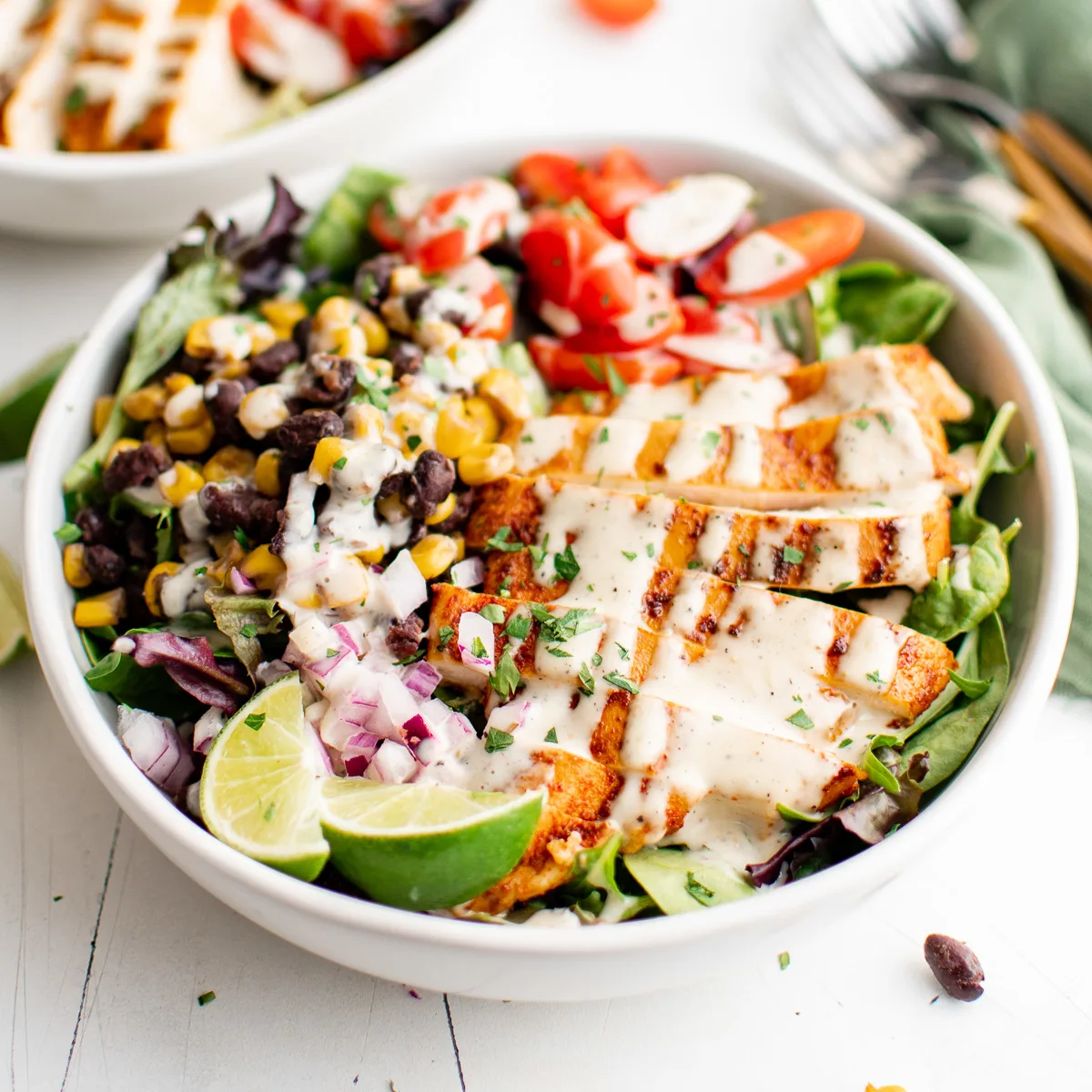 Side view of spicy ranch dressing drizzled over salad.