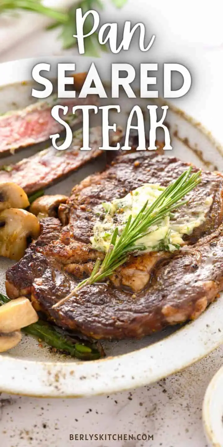 Close up view of a pan seared steak on a plate.