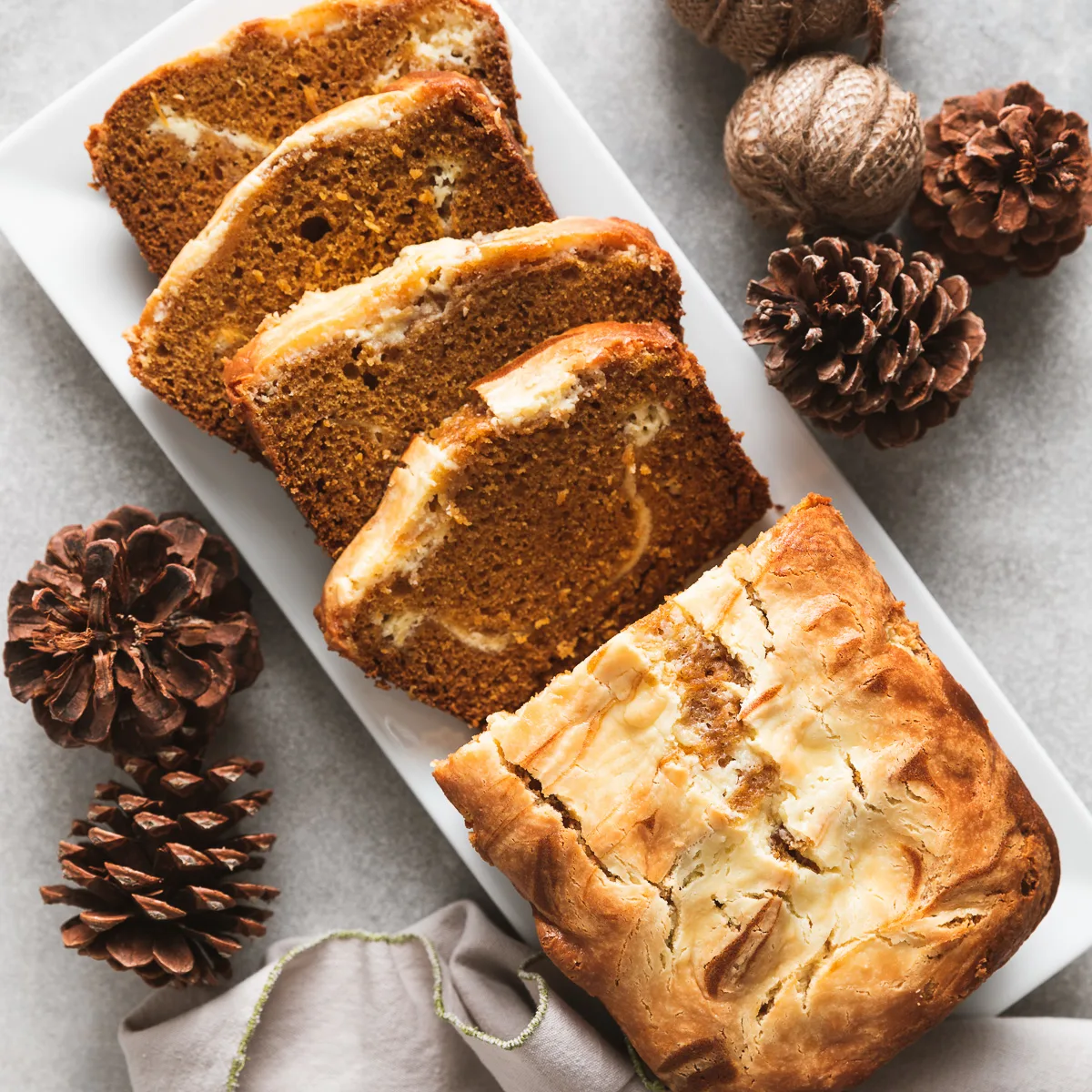 Top down view of a loaf of cream cheese pumpkin bread on a platter.