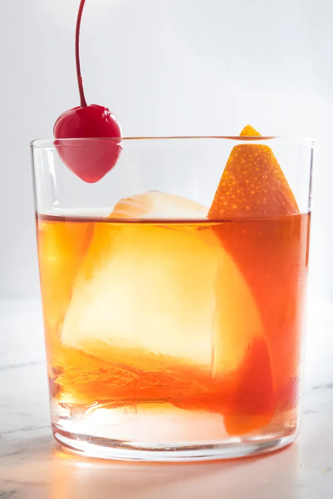 Cherry being dropped into a cocktail.