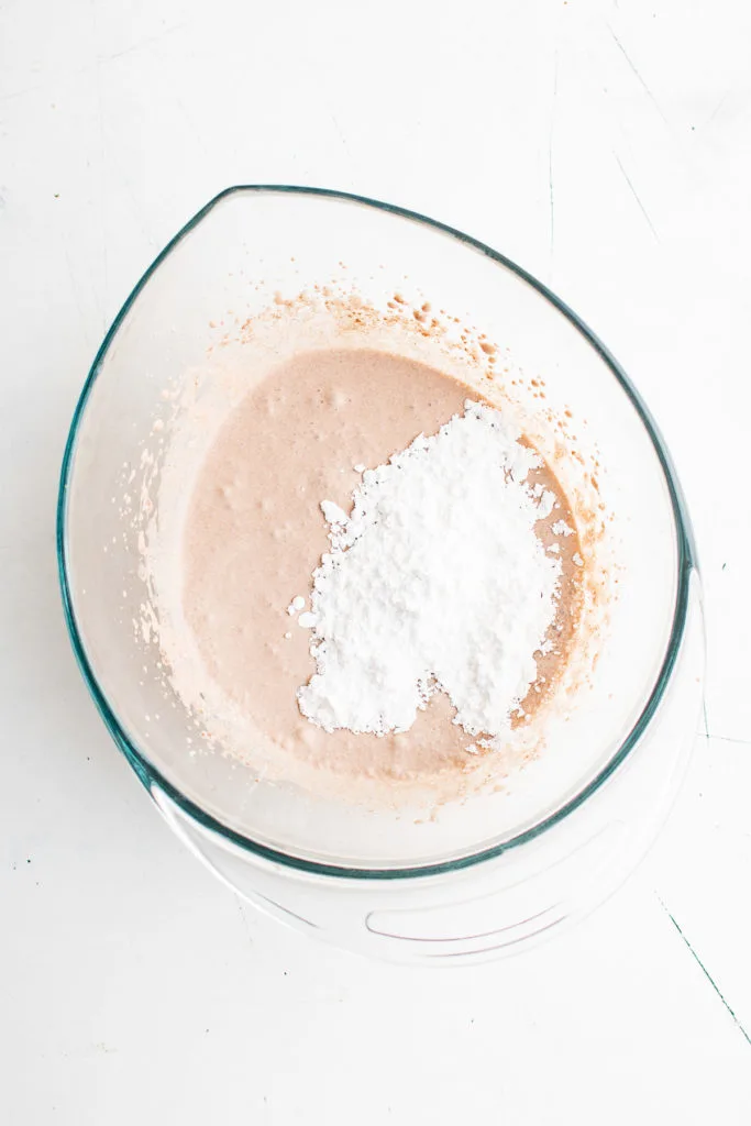 Powdered sugar on top of liquid hot chocolate.