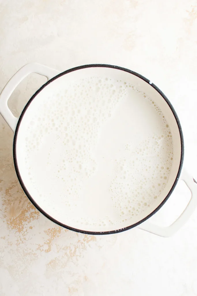 White chocolate chips in a pan of warm milk and vanilla.