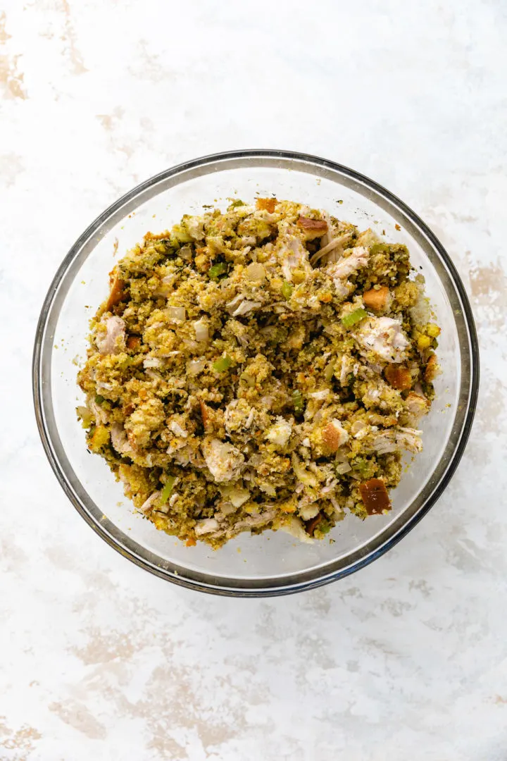 Cornbread, chicken and and vegetable mixture in a bowl.