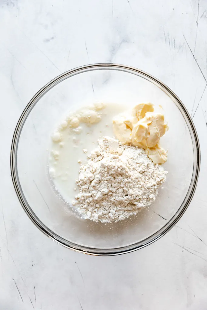 Top down view of bisquick, mayo, and milk in a bowl.