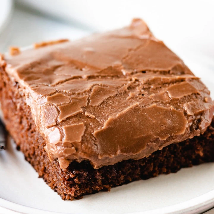 Close up view of a slice of coca-cola cake on two plates.