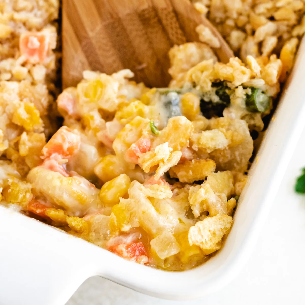 Close up view of veggie casserole being scooped from a dish.