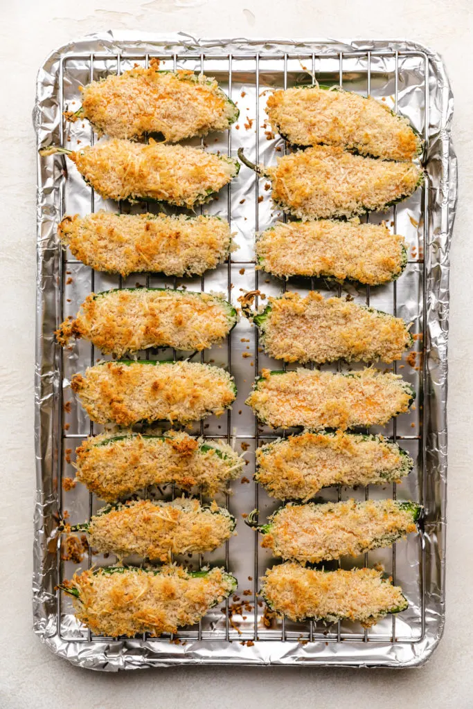 Baked jalapeño poppers on a baking sheet.