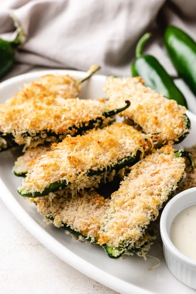 Side view of stuffed jalapeños on a plate.