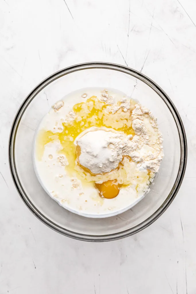 Flour, eggs, buttermilk, sugar, butter, and other ingredients in a bowl.