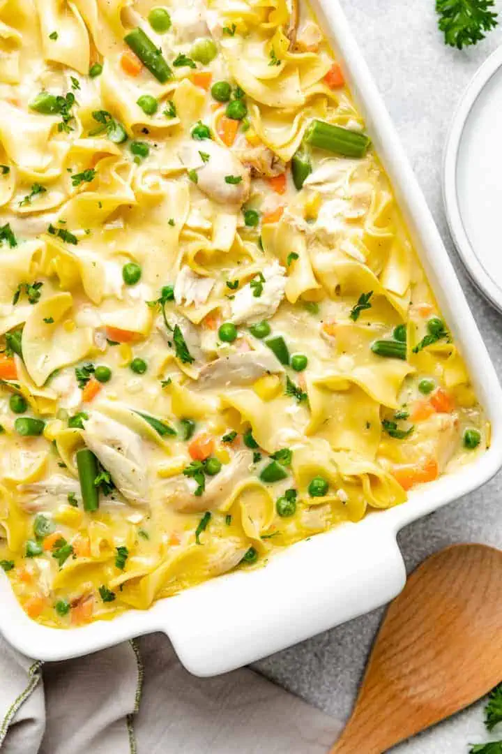 Top down view of chicken and noodles in a casserole dish.