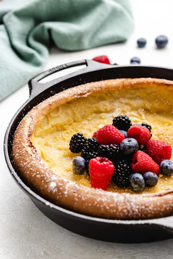 Side view of a cast iron pan holding a pancake.