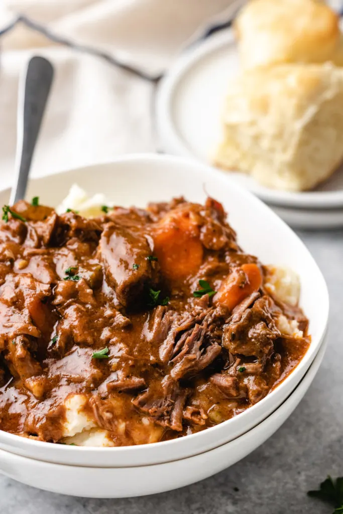 Close up view of a portion of guinness irish stew in a white bowl.