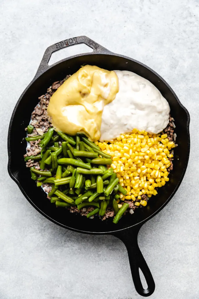 Cream soups, green beans, and corn on top of ground beef.