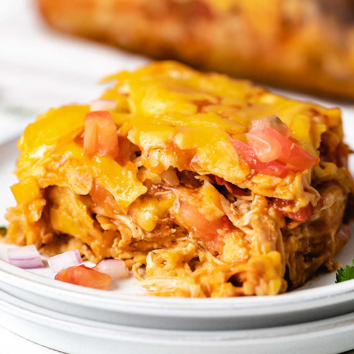 Slice of chicken enchilada casserole on a plate.