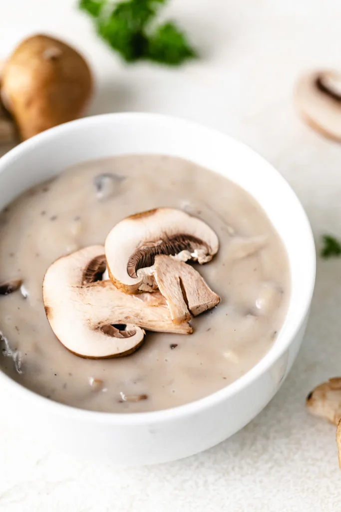 Mushroom slices laid over mushroom soup.