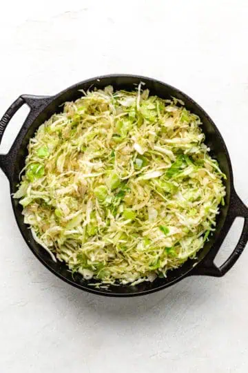 Shredded green cabbage in a pan.