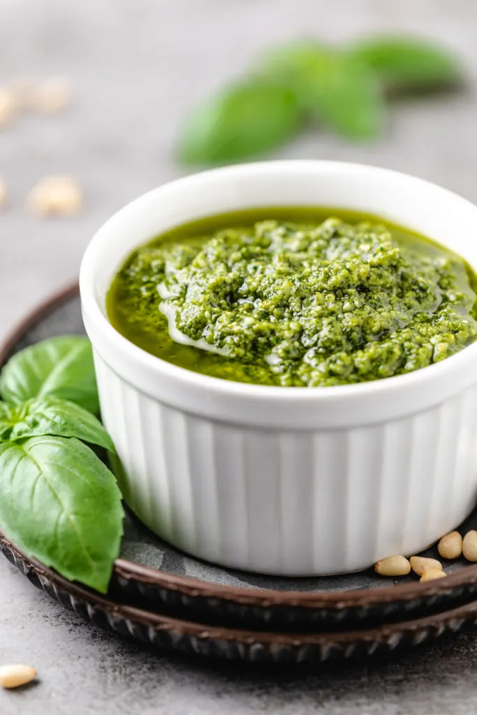 White ramekin filled with basil olive oil sauce.