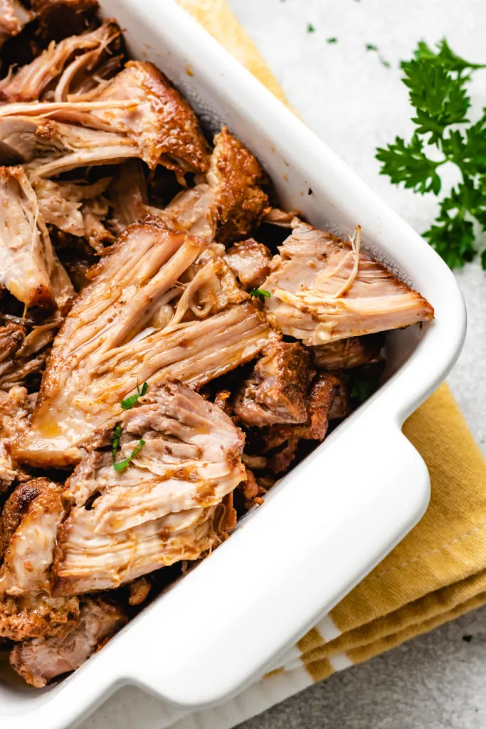 Shredded crockpot boneless pork ribs in a pan.