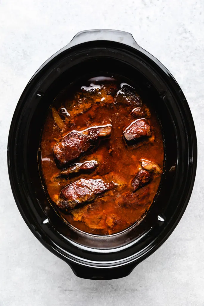 Crockpot filled with country style pork ribs.